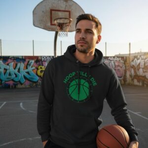 Man in black hoodie holding basketball on outdoor court.